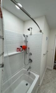Bathroom with shower and bathtub, white tiles.